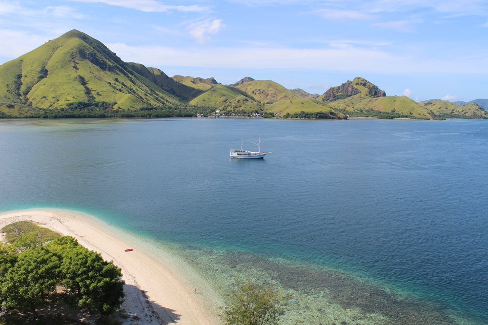 A boat is sailing into Kelor on a sunny day | Hello flores