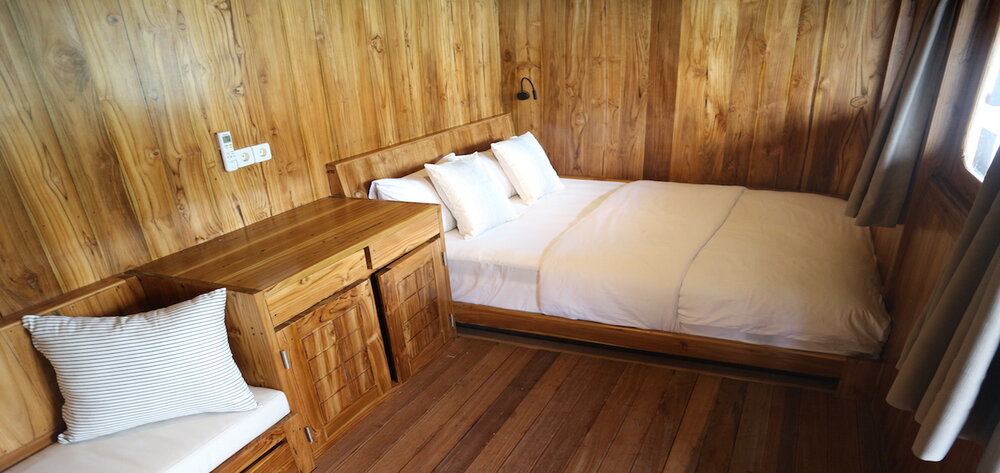 A bed with drawers inside Andamari liveaboard cabin | Hello Flores