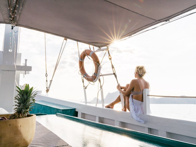 A female guest is relaxing on the starboard side of Royal Fortuna liveaboard while enjoying the view