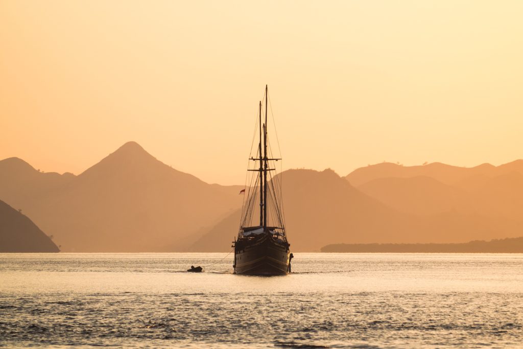 A boat is sailing in the evening